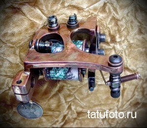 Фото винтажной тату-машинки ручной работы с медным корпусом. Старинное оборудование для татуировки.