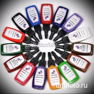 Фото тату: круглая палитра из 15 бутылочек с пигментами для татуировки разных цветов.
