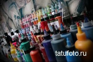 Фото тату красок: большая палитра красок для татуировки разных цветов, расположенных на полке в тату-салоне.