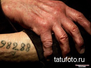 Фото тату: Рука пожилого мужчины с татуировкой, содержащей дату "9.8.2.8.8". Черно-белое изображение, минималистичный дизайн, исторический контекст.