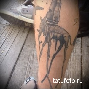 Фото тату сюрреалистичного слона на икре. Черно-белый рисунок татуировки, вдохновленный работами Сальвадора Дали, с текучими формами и длинными ногами.