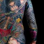 Фото тату на всю спину: изображение самурая с мечом, окруженного яркими цветами и волнами. Детальный рисунок татуировки в японском стиле.