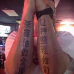 Фото парных татуировок с длинными вертикальными колоннами черных иероглифов на предплечьях мужчины и женщины.