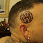 Фото тату на виске с изображением логотипа Volkswagen. Необычное и смелое решение для автолюбителей.