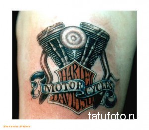 Фото тату: детализированное изображение двигателя Harley Davidson на руке. Реалистичный рисунок, выполненный в черно-серых тонах.