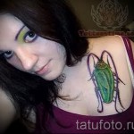 Тату насекомые - зеленый таракан на груди у девушки