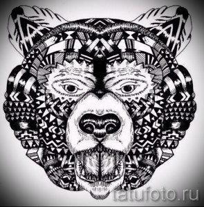 Фотография черно-белого эскиза татуировки медвежьей головы, заполненной сложными геометрическими узорами в этническом стиле.