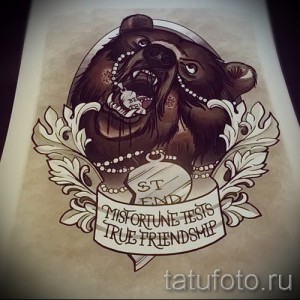 Фотография цветной татуировки медведя, держащего в лапах ребенка, окруженного традиционными узорами и лентой с надписью.