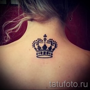 Фото татуировки короны на задней части шеи. Черно-белый рисунок татуировки, выполненный в детализированном стиле.