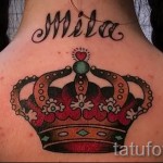 Фото тату яркой короны и имени "Mila" на шее. Цветная татуировка в стиле олдскул, выполненная с использованием насыщенных цветов и четких контуров.