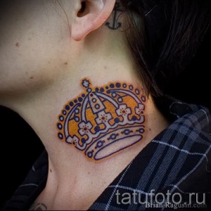 Фото яркой татуировки короны на шее. Рисунок татуировки выполнен в оранжево-фиолетовых тонах с использованием контуров.