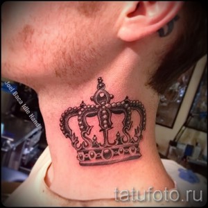 Фото детализированной татуировки короны на шее мужчины. Черно-серый рисунок татуировки с высокой проработкой деталей.