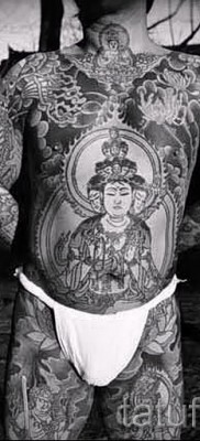 Древняя татуировка с буддой на теле мужчины