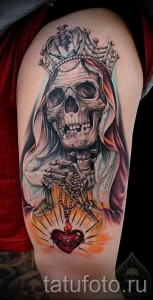 Фото тату черепа в короне с четками на плече. Детализированный рисунок татуировки в стиле реализм.