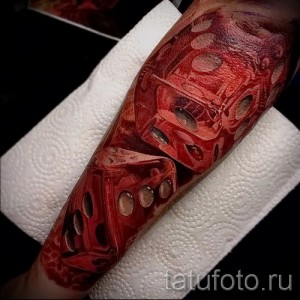 Фото тату: реалистичный рисунок кубика Рубика, словно прорвавшего кожу на предплечье, с эффектом кровоподтеков и рваных краев.