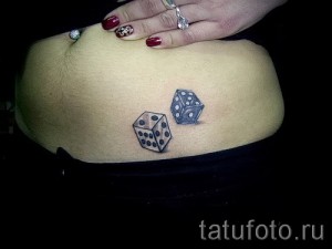 Фото тату на животе с изображением двух игральных костей. Соблазнительный и стильный рисунок в черно-белой гамме.