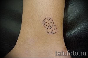Фото тату на лодыжке с изображением двух игральных костей. Простой и элегантный рисунок в черно-белой гамме.