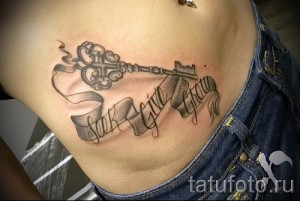 Фото тату на боку: старинный ключ с лентой и надписью 'Live Laugh Love', выполненный в черно-серых тонах с детализированной проработкой.