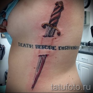 Фото тату на боку: кинжал, пронзающий сердце, и надпись "Death Before Dishonor" в традиционном стиле.