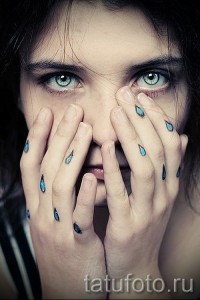 Фото тату маленьких слез на руках девушки. Несколько минималистичных рисунков татуировок, выполненных черным цветом, символизирующих печаль или потерю.