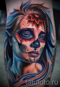 Фото тату: красочная татуировка в стиле Sugar Skull на предплечье, изображающая женское лицо с черепом.