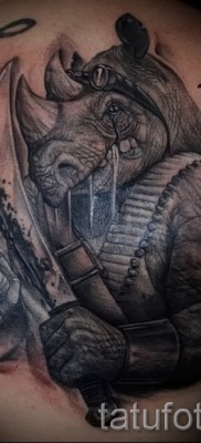 Фото пример тату носорог — носорог человекоподобный воин с оружием — выполнена на груди