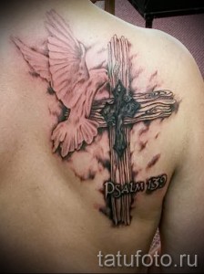 Фото тату: Голубь, парящий над крестом с надписью 'Psalm 139', выполненный в розовых и черных тонах на спине.
