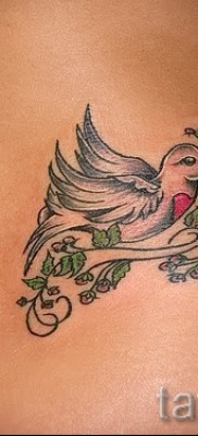 Фото тату голубь на боку (поясница) — выполнена на теле стройной девушки