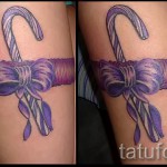 Фото тату подвязка с фиолетовым бантиком и конфеткой