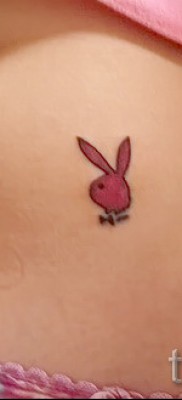 Фото татуировки с кроликом — символ плейбой внизу живота возле трусов у девушки