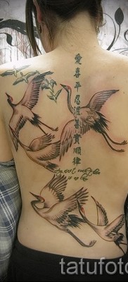тату журавль фото пример — стая журавлей и иероглифы в женской татуировке на спине