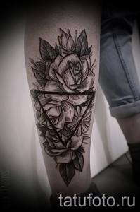 Фото тату: татуировка на ноге с изображением роз, заключенных в треугольник. Современный и стильный рисунок татуировки в черно-белых тонах.