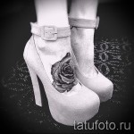 Фото тату: черная роза, выполненная в технике татуировки с высокой детализацией, на женской лодыжке. Элегантный и стильный рисунок.