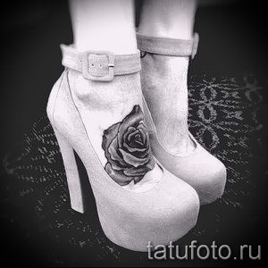 Фото тату: черная роза, выполненная в технике татуировки с высокой детализацией, на женской лодыжке. Элегантный и стильный рисунок.