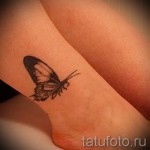 Фотография татуировки на лодыжке: изображение бабочки с детализированными крыльями, выполненное в черно-серых тонах.