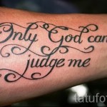 Фото тату на предплечье с надписью 'Only God can judge me' выполненной красивым шрифтом с декоративными элементами. Смысловая и выразительная татуировка.