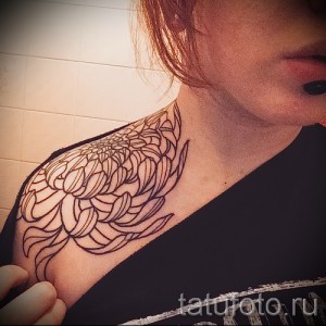 Фото тату: Черная контурная татуировка хризантемы на шее. Минималистичный рисунок татуировки с четкими линиями.