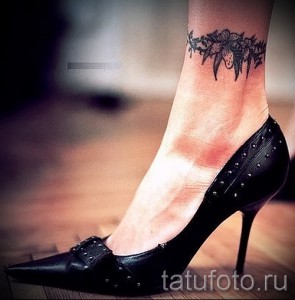 Фото тату с изображением паука и кружевного узора на лодыжке. Оригинальный рисунок татуировки, выполненный в черных тонах.