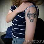 Фото готовой тату знак зодиака телец - голова быка на левом плече у девушки