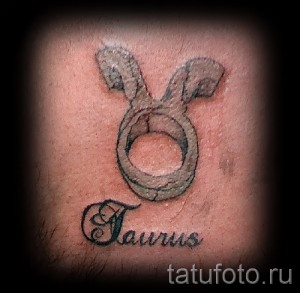 Фото тату символа зодиака Телец на коже. Изображение знака с подписью 'Taurus'.