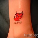 Фото готовой тату знак зодиака телец - маленький красный бычок и надпись