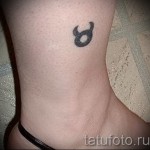 Фото готовой тату знак зодиака телец - маленький символ внизу ноги женщины