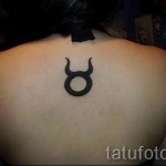 Фото готовой тату знак зодиака телец - по середине спины - между лопатками у женщины