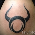 Фото готовой тату знак зодиака телец - простой символ на плече мужчины