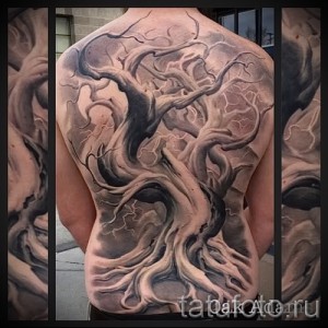 Фото тату: большая татуировка дерева на спине, выполненная в стиле blackwork. Монохромный рисунок татуировки.