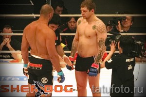 Фотография двух бойцов MMA перед боем, демонстрирующая татуировки на руках и плечах одного из них. Видны детали рисунков и спортивная подготовка.
