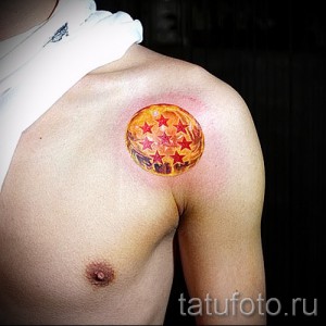 Фото татуировки на плече, изображающей шар с семью звездами из аниме Dragon Ball. Яркий и детализированный рисунок.