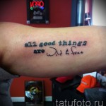 Фото минималистичной татуировки на запястье с надписью 'all good things are wild & free' выполненной простым шрифтом.