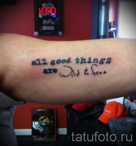 Фото минималистичной татуировки на запястье с надписью 'all good things are wild & free' выполненной простым шрифтом.