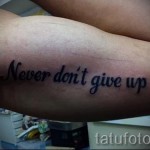 Фото тату: Простая татуировка надписи 'Never don't give up', выполненная черным цветом на предплечье, мотивирующая и вдохновляющая.